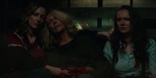 Karen holds a bleeding Laurie while they sit next to Allyson in 2018's Halloween