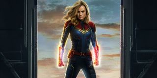 Captain Marvel standing, fists ready, in a hanger