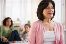 Grandmother looking sad with family in the background