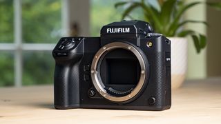Front of the Fujifilm GFX100 II on a wooden table no lens attached