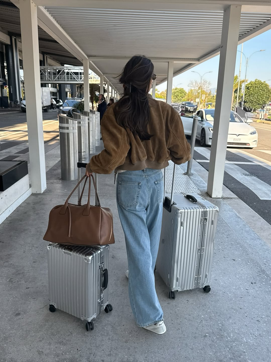 Felicia Akerstrom at the airport with two suitcases.