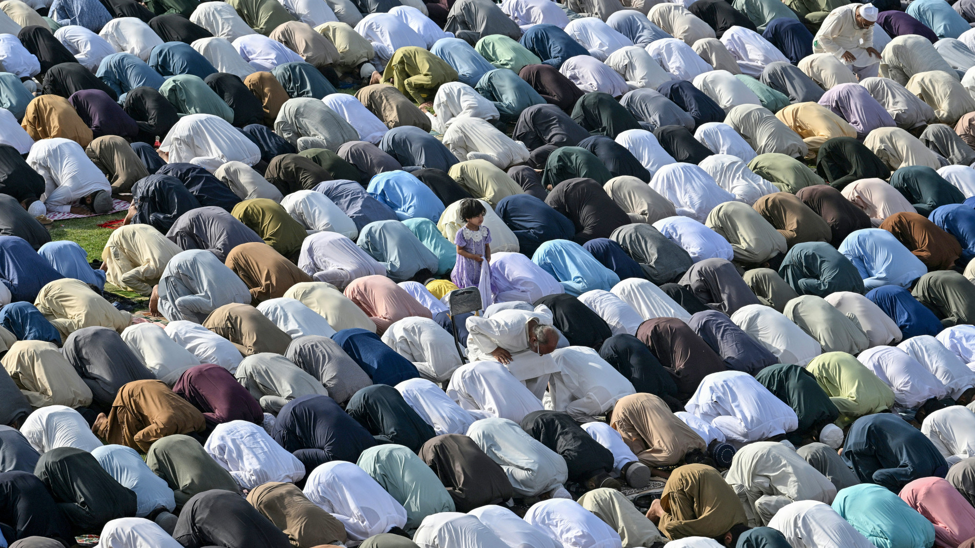 A child stands amongst praying Muslims
