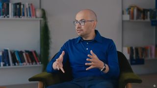 Demis Hassabis, Google DeepMind CEO, sitting on a chair, gesticulating