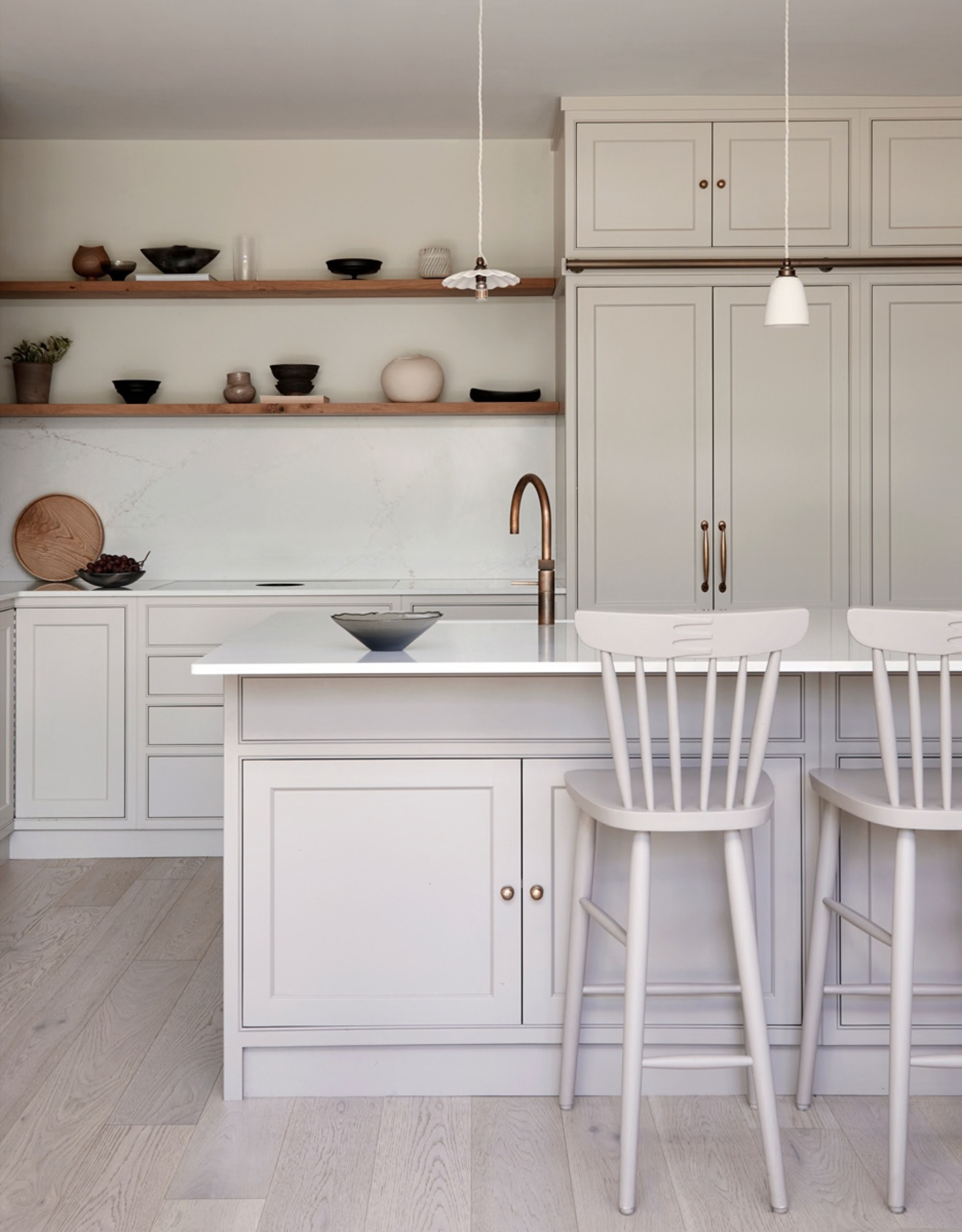 A white kitchen with wooden shelves of crafts and ceramics