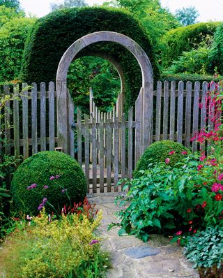Moon gate inspired garden gates with topiary arched hedge