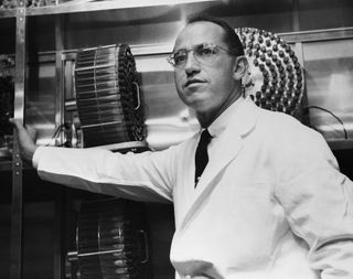 Dr. Jonas Salk standing in the University of Pittsburgh lab in which he developed a vaccine for polio.