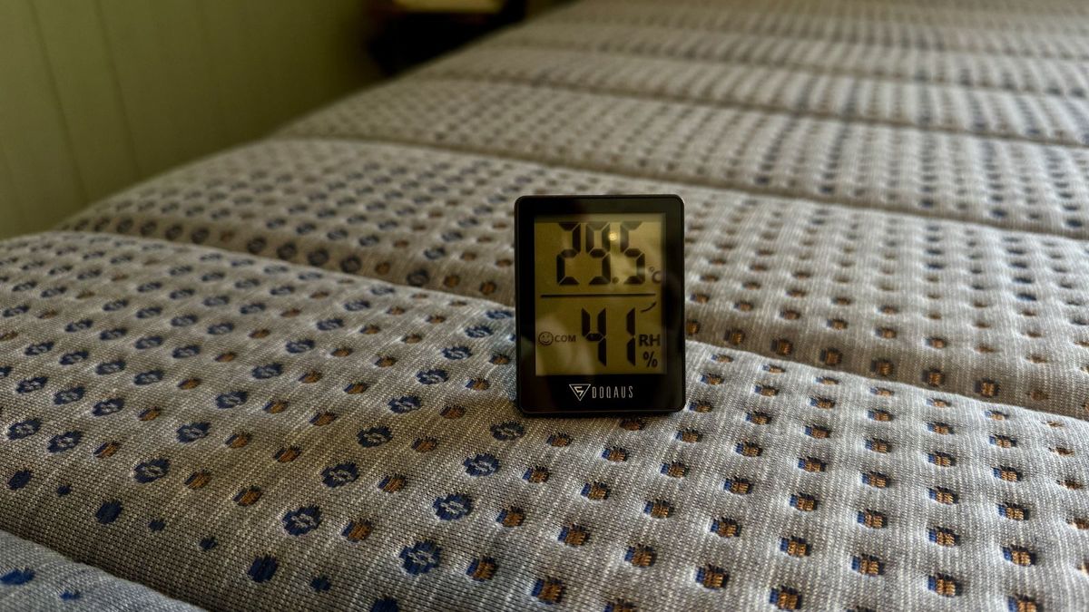A thermostat showing 29.5 degrees celsius on the surface of Brooklyn Bedding Copperflex Memory Foam Mattress. The cover is grey with navy and bronze speckles.