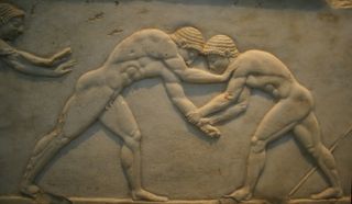 Ancient Greek Bas relief of men wrestling.