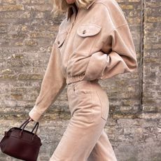 Elsa Hosk wearing tan boots, tan suede pants, and a matching top. 