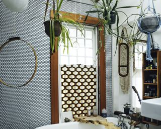 a boho bathroom with plants hanging from the ceiling