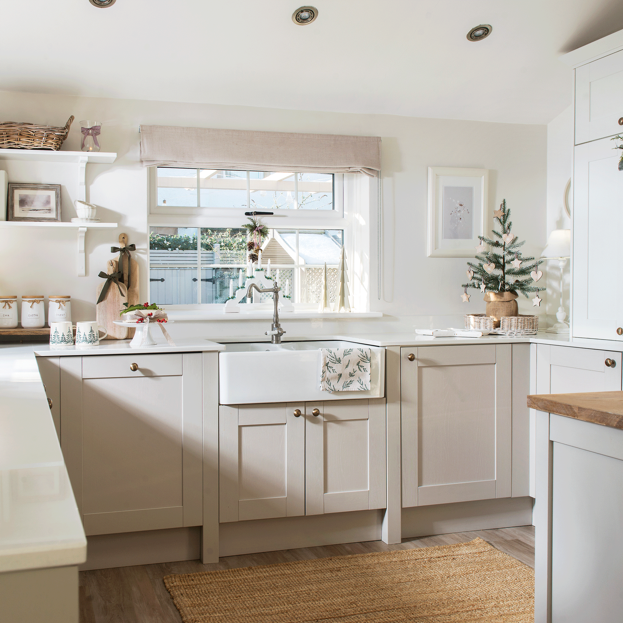 a neutral stone coloured Shaker kitchen with a Belfast sink, Roman blinds and open shelving
