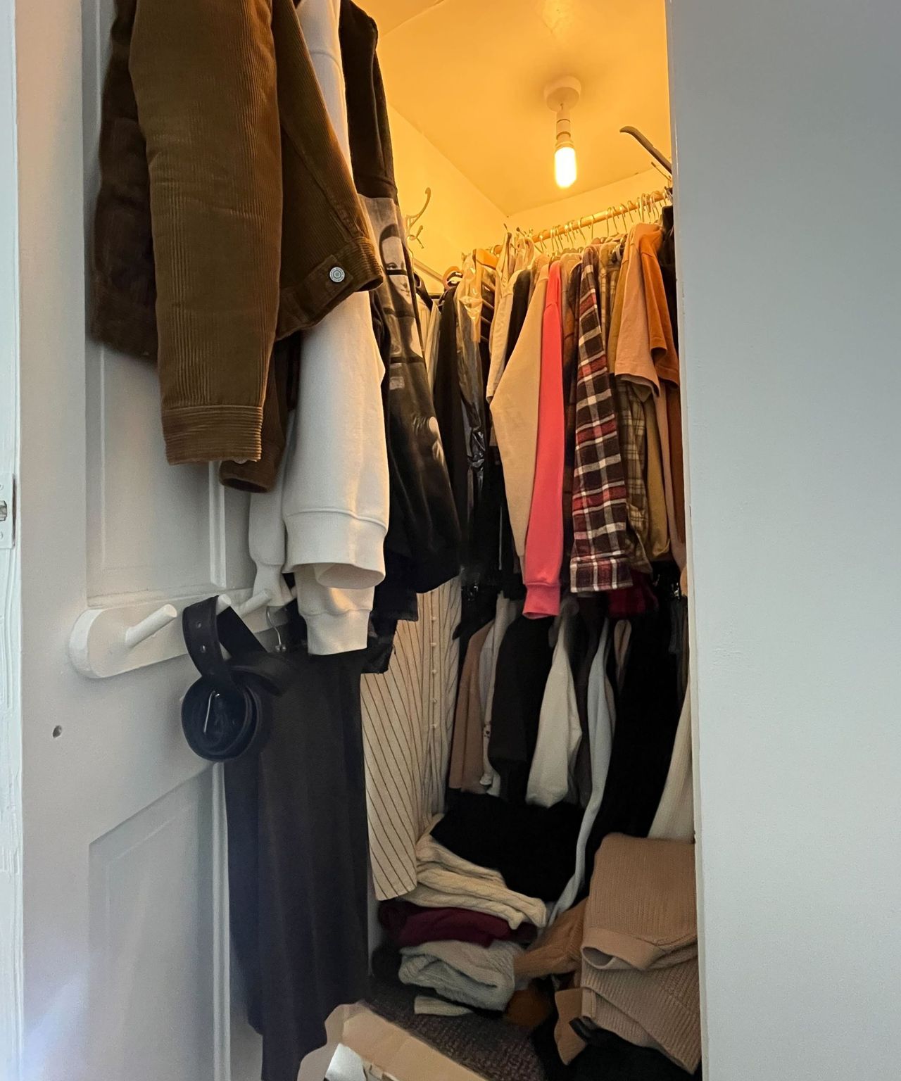 A small awkward closet with an orange light at the top