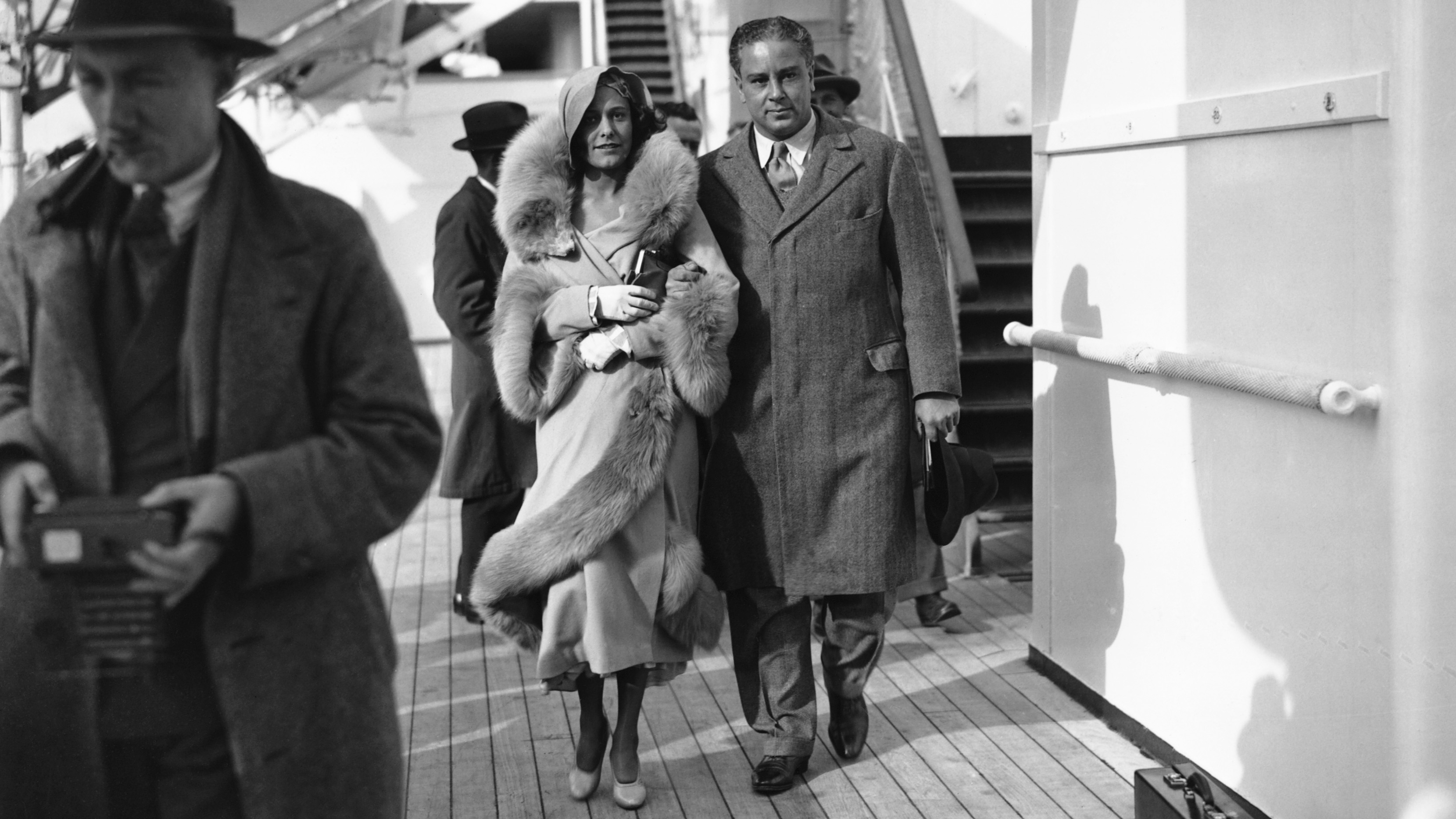 A well-dressed woman and man walking across the deck of a cruise ship in the 1930s