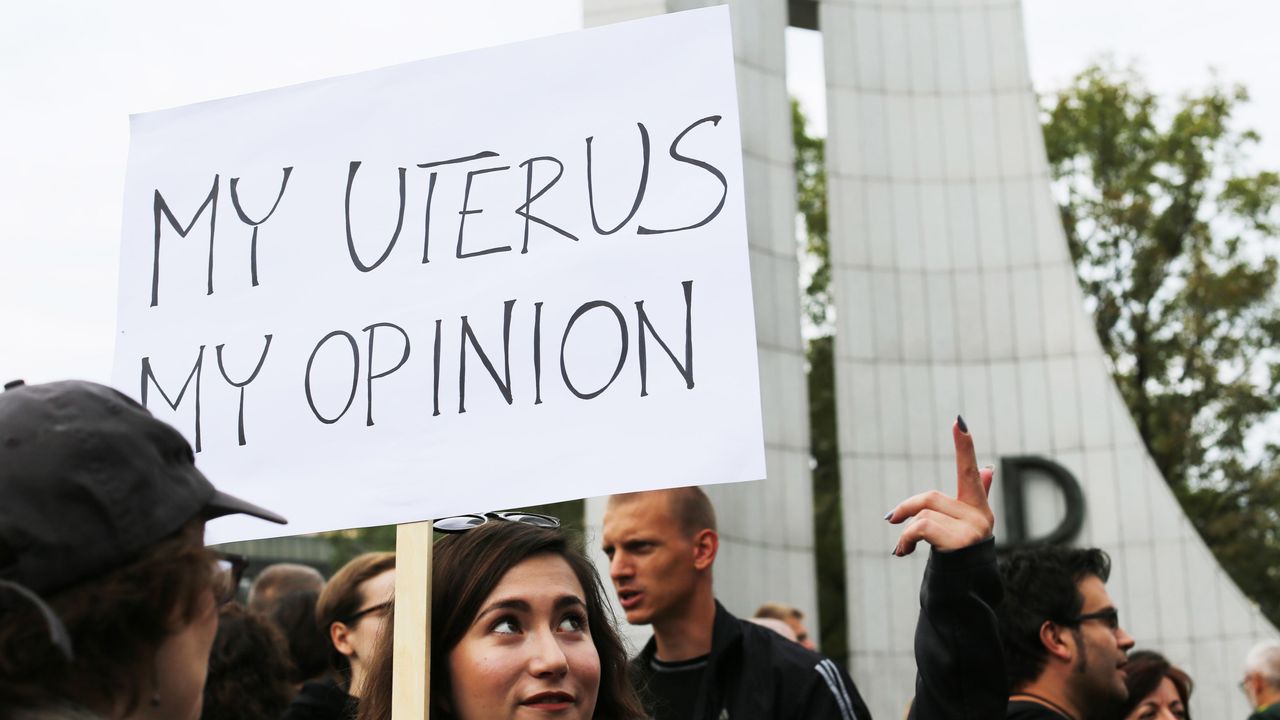 Woman holding &quot;My uterus, my opinion&quot; sign at abortion protest