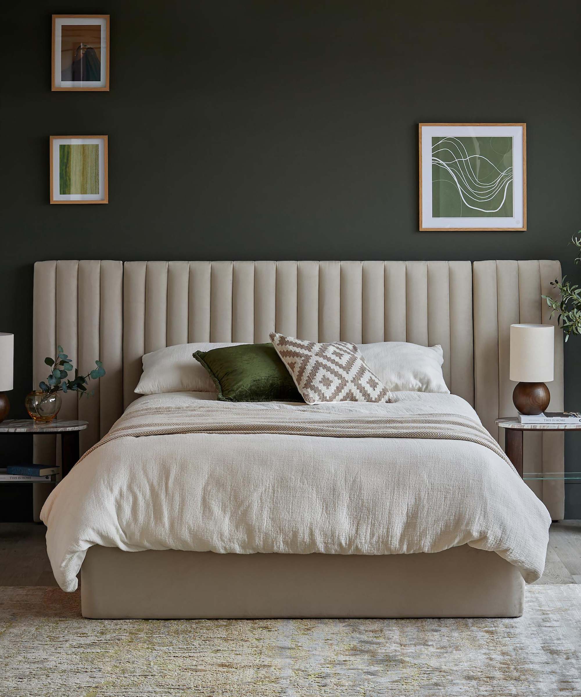 bedroom with green walls, cream fluted padded headboard behind bed with cream bedding