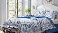 Some of the items in the bedding sales on a bed: a blue and white quilt with matching pillowcases.