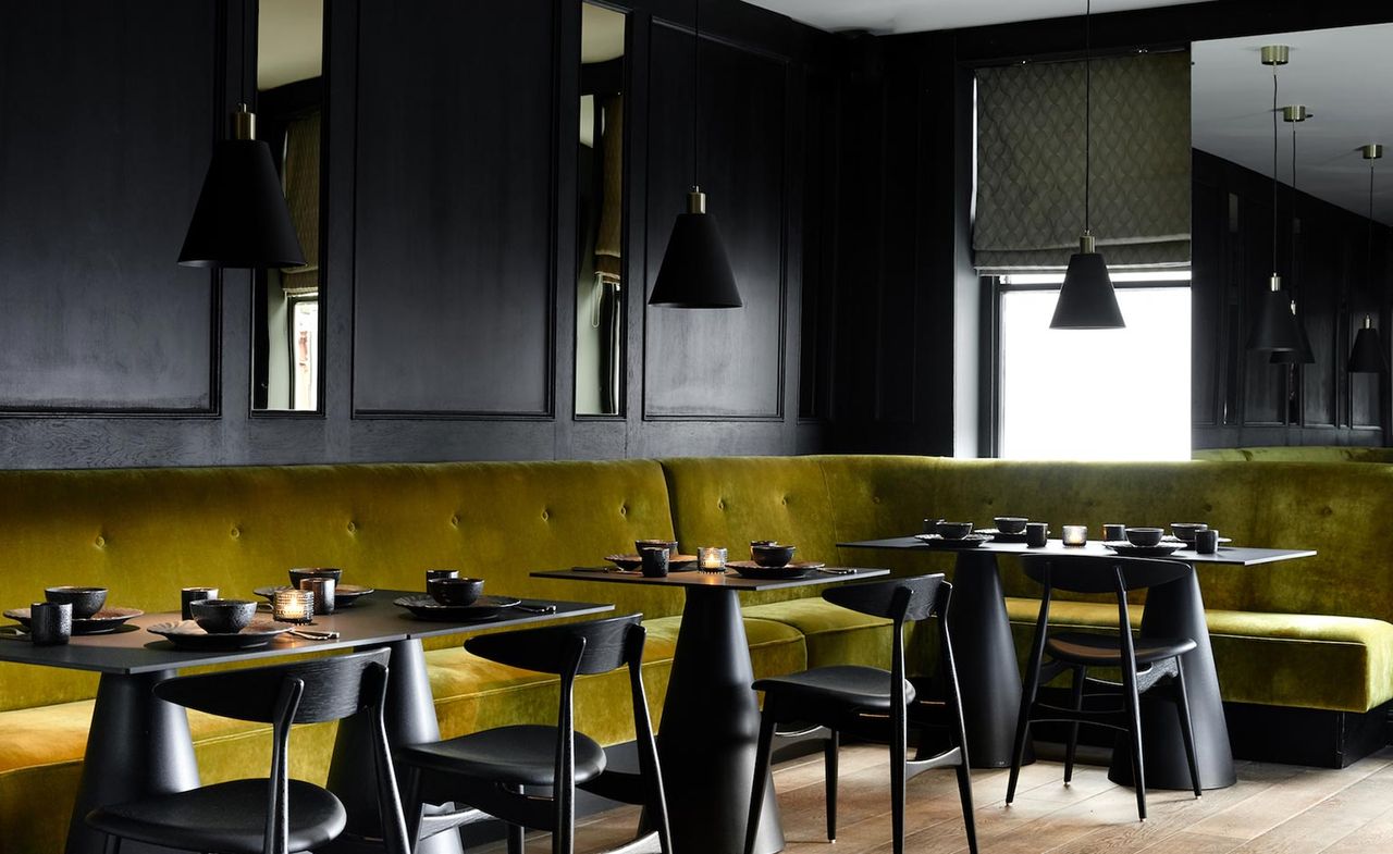 Black wood panelling, sculptural tables and chairs.