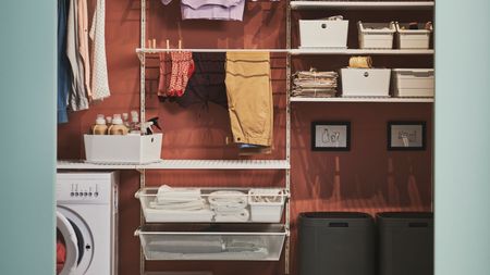 laundry room with multipurpose shelving from IKEA with a washing machine and storage behind green sliding doors