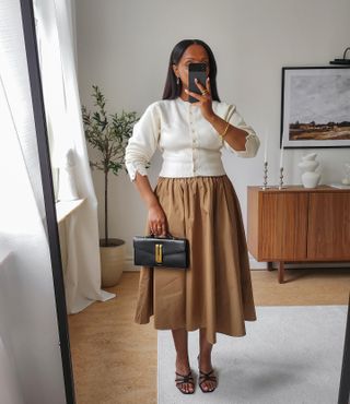 Classic fashion style: @femmeblk wears a cream cardigan with a full skirt