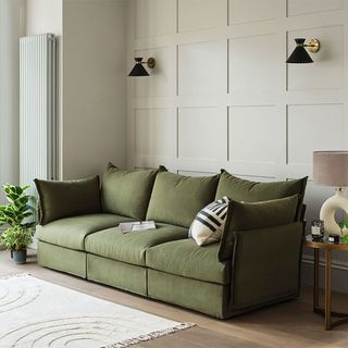 Modern grey living room ideas with panelled wall and green sofa