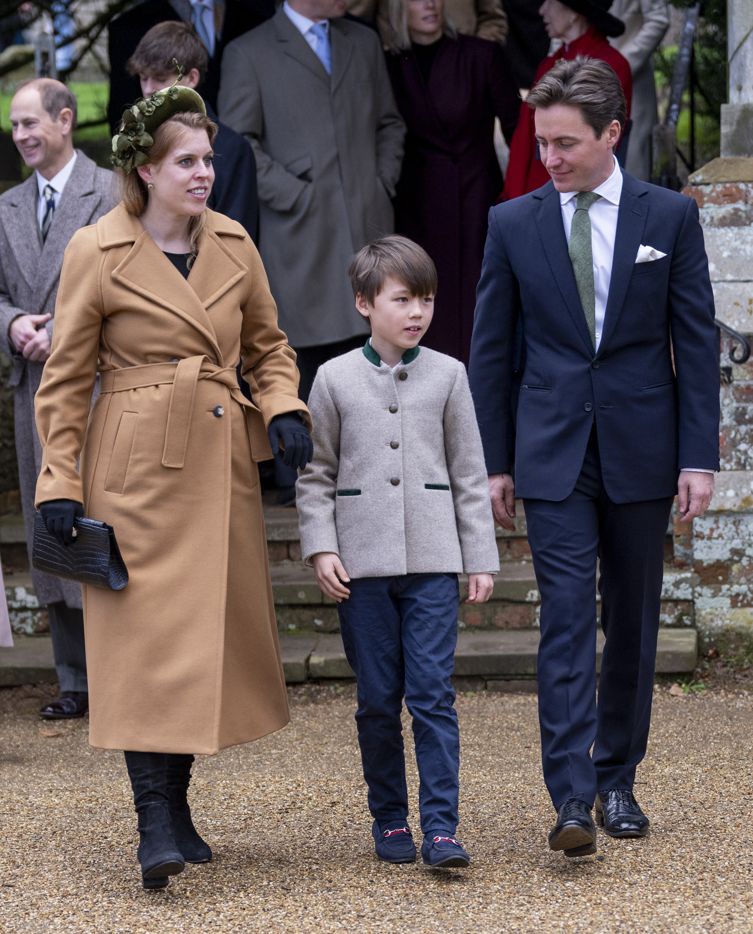 Princess Beatrice in a camel coat walking next to her stepson Christopher and husband Edoardo Mapelli Mozzi at Christmas church service