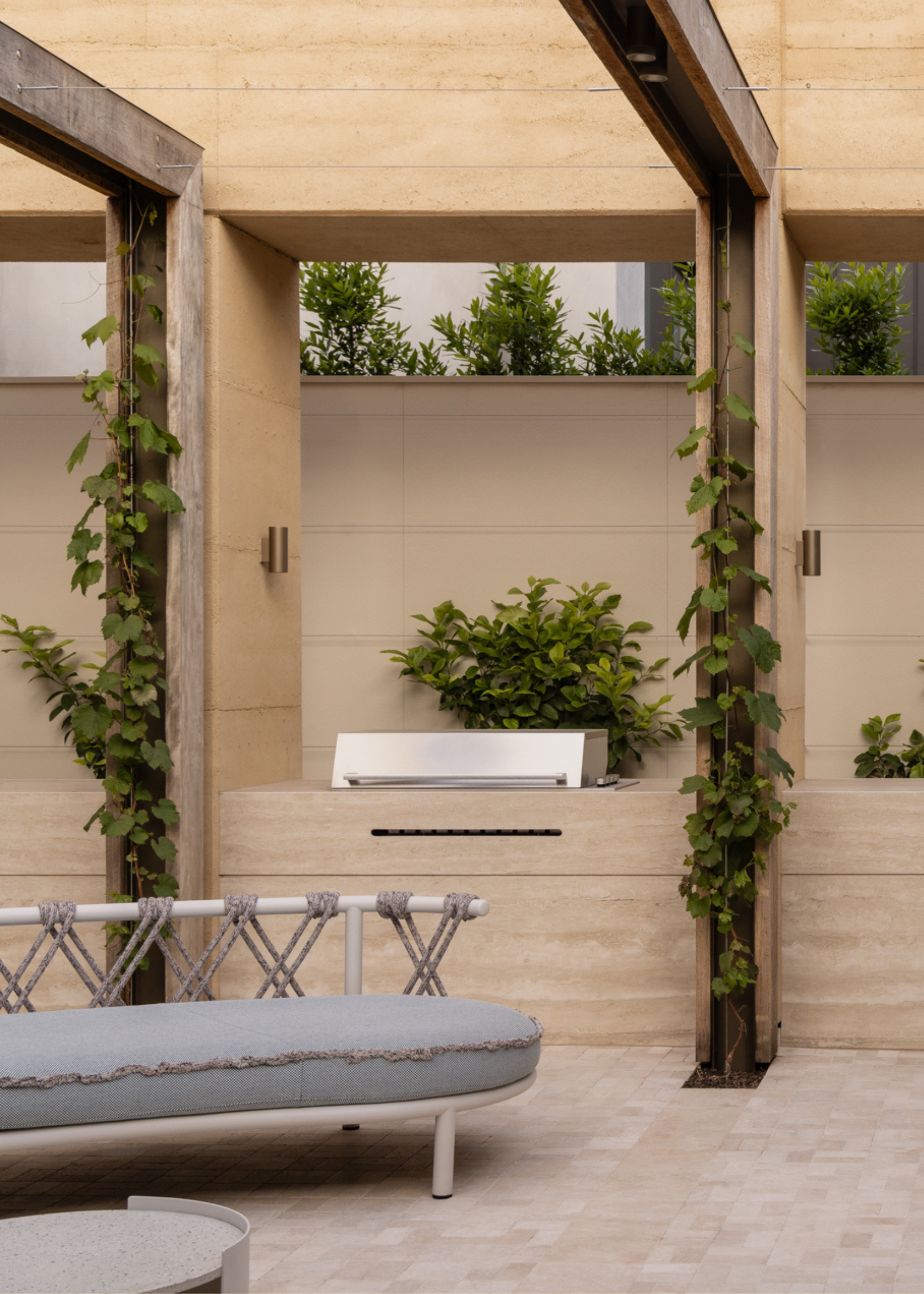 An outdoor kitchen with a garden sofa