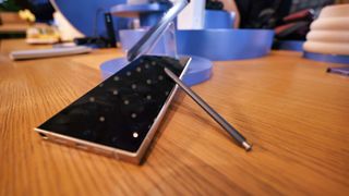 Samsung Galaxy S24 Ultra phone with a stylus on a wooden surface