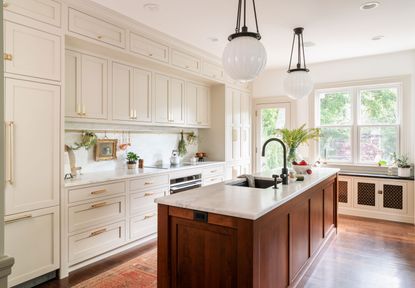an off white kitchen with detailed cabinets and crown molding