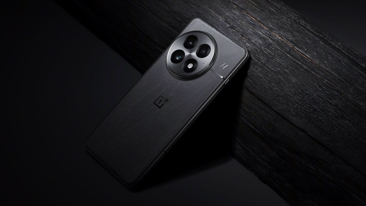 OnePlus 13 phone in black proped up against a dark wood grained plank