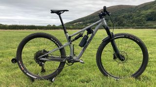 Merida One-Twenty 700 bike in field with hills behind