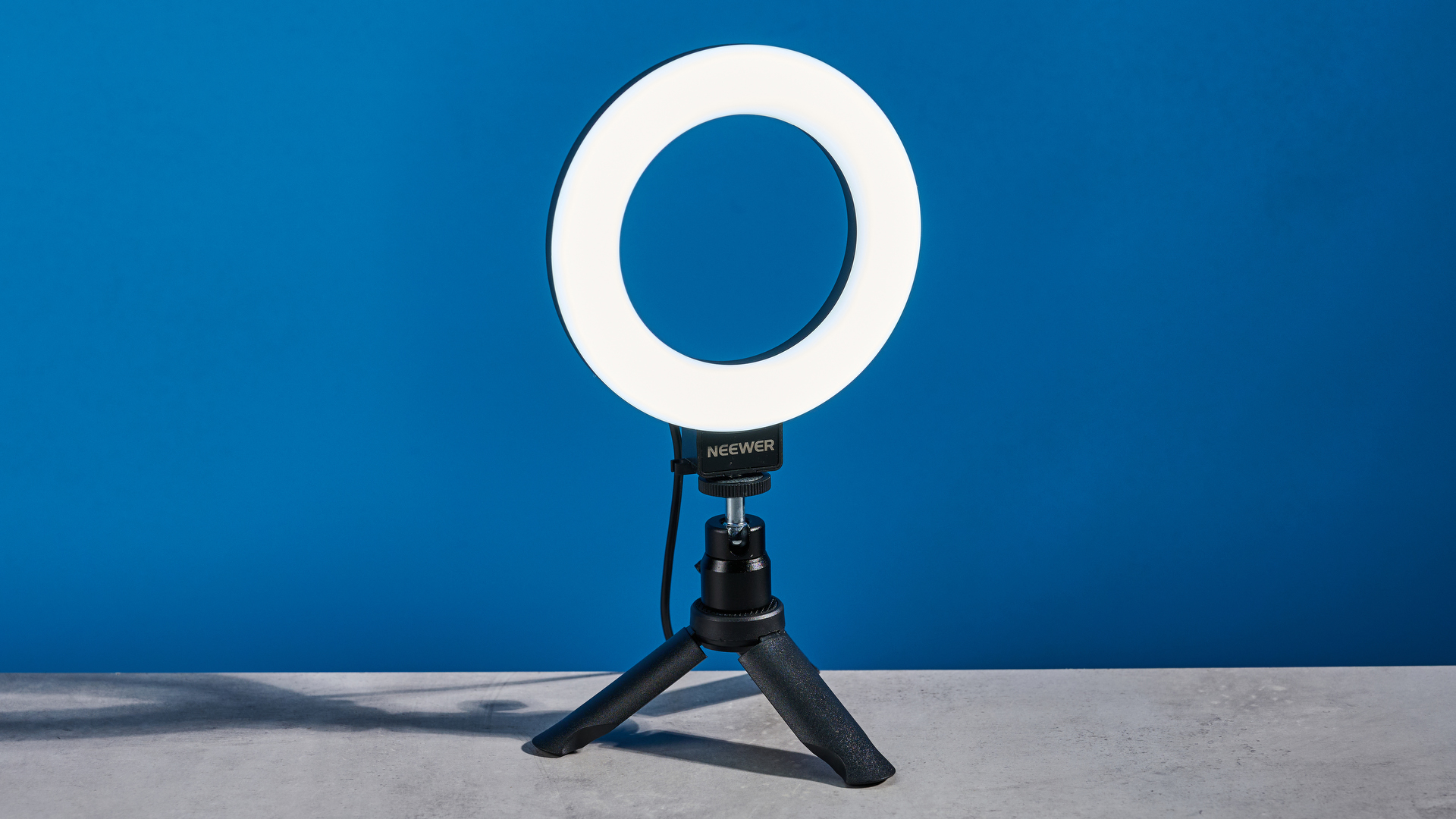 The Neewer Basics BR60 5" Ring Light photographed in front of a blue background.