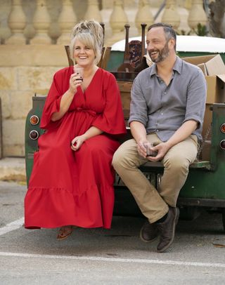 Jean (Sally Lindsay) and Dom (Steve Edge) enjoy a giggle sitting in the back of a truck filled with antiques