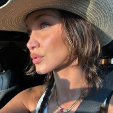 Bella Hadid taking a selfie in the sunlight with fluttery eyelashes