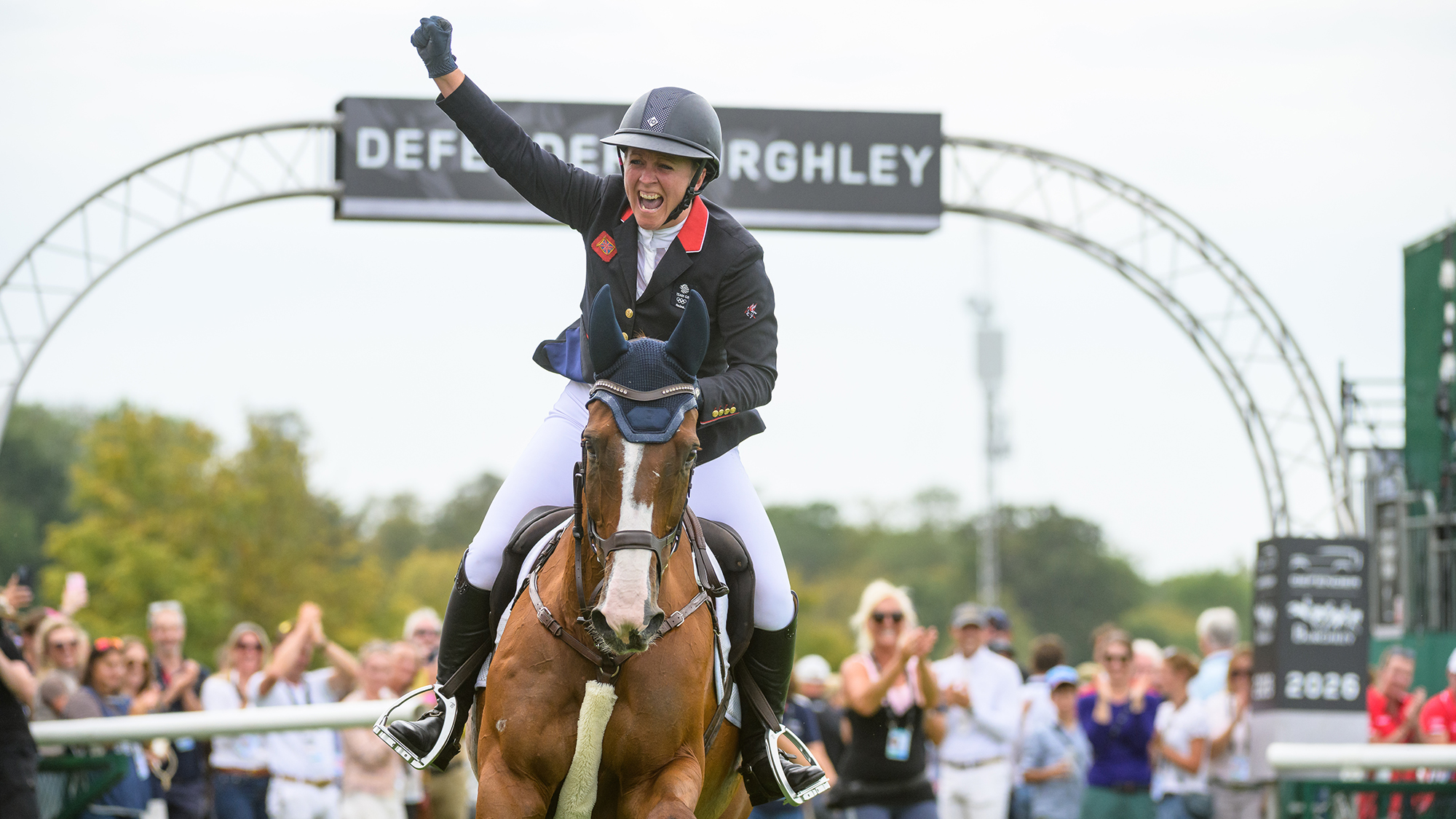 Gemma Stevens punches the air as she takes her lap of honour on chestnut horse with a white blaze Chilli Knight after her winning showjumping round at the 2026 Defender Burghley Horse Trials