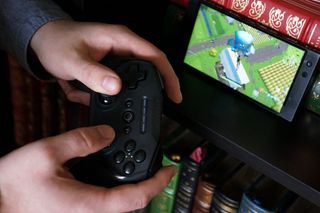 A gamer plays Fortnite on a Razer Phone 2 using a SteelSeries Stratus Duo