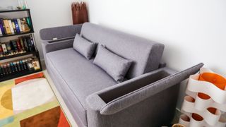 Emma Sofa Bed's armrests open to reveal storage