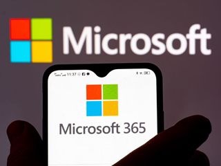 Microsoft 365 logo displayed on a smartphone with Microsoft logo in the background.