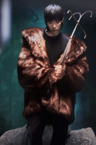 A model wears an Elden Ring faux fur coat.
