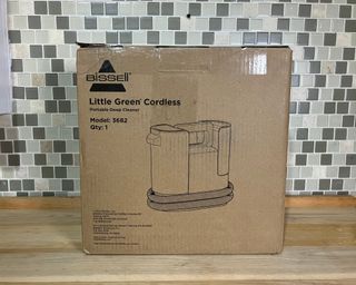 Bissell Little Green Cordless Portable Carpet Cleaner in cardboard box on wooden kitchen worktop with tiled backdrop