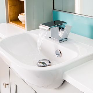 white washbasin with cabinets and shelf