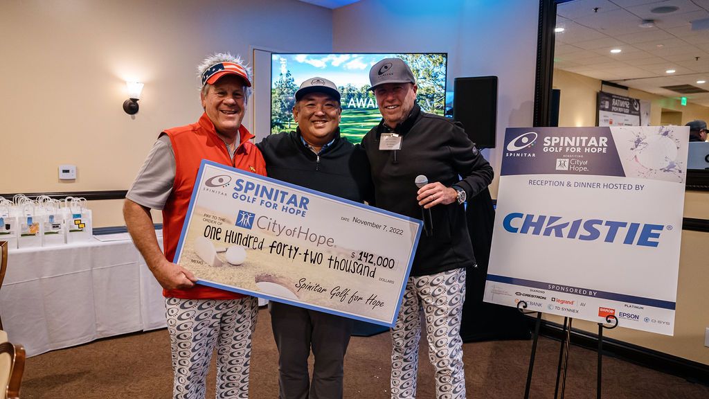 Three people holding a big check for the record $142,000 Spinitar raised at Golf for Hope.