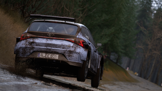 A car takes off down a muddy road, spraying dirt, in Assetto Corsa Rally.