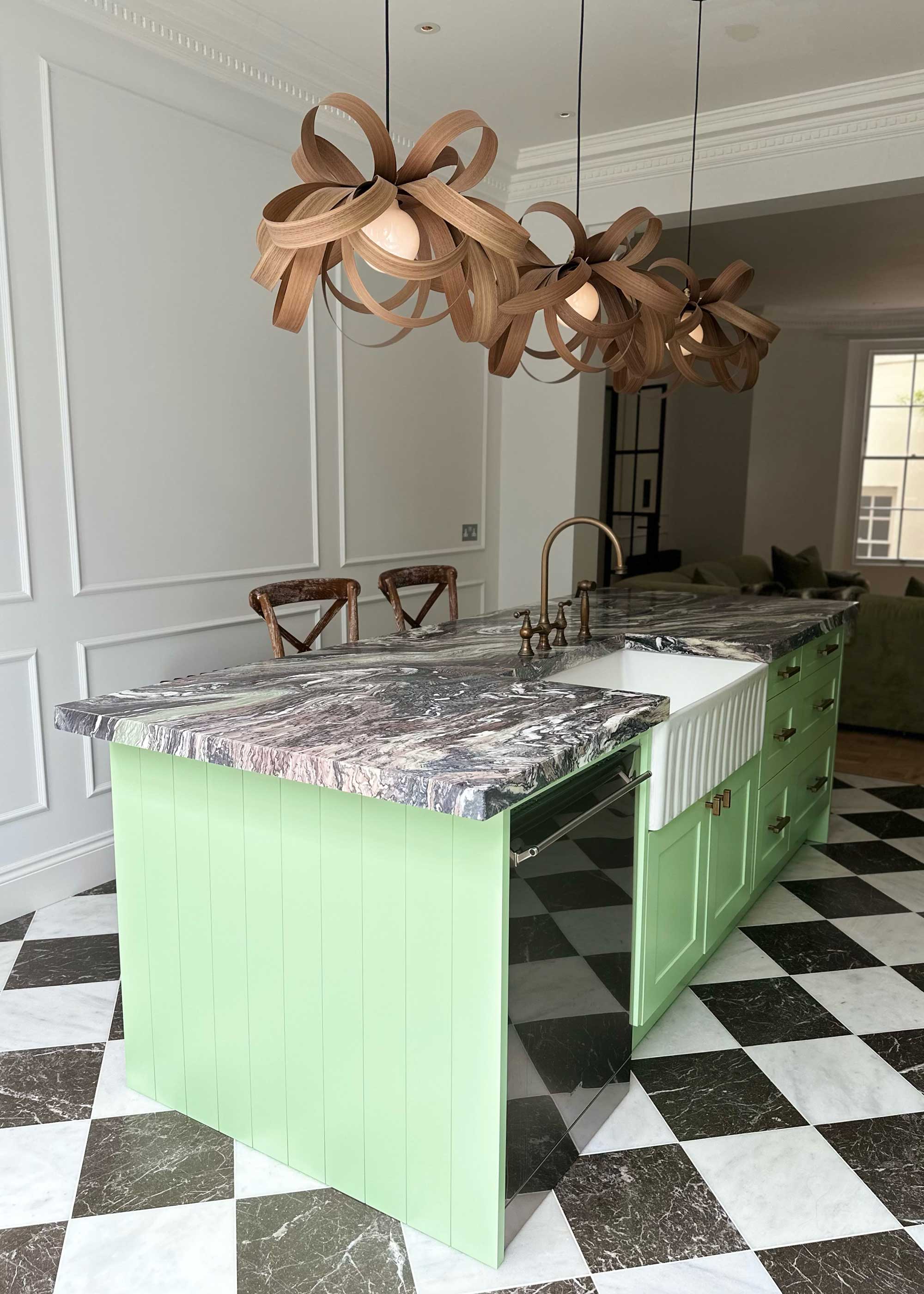 mint green kitchen island with black and white chequerboard floor and marble worktops