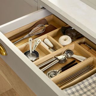 Wood Drawer Inserts filled with cutlery in a drawer.