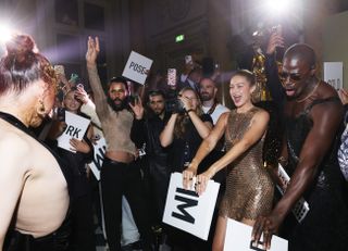 A photo of Gigi Hadid and actor Moses Sumney dancing at a fragrance launch party.