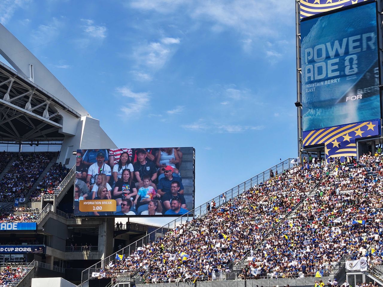 Spectators in the stands and two large TV screens