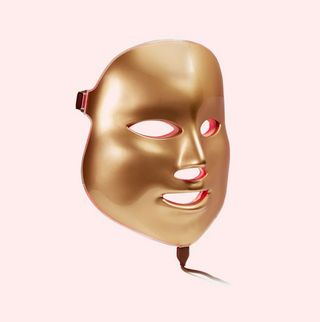 gold mask mask on a pink background