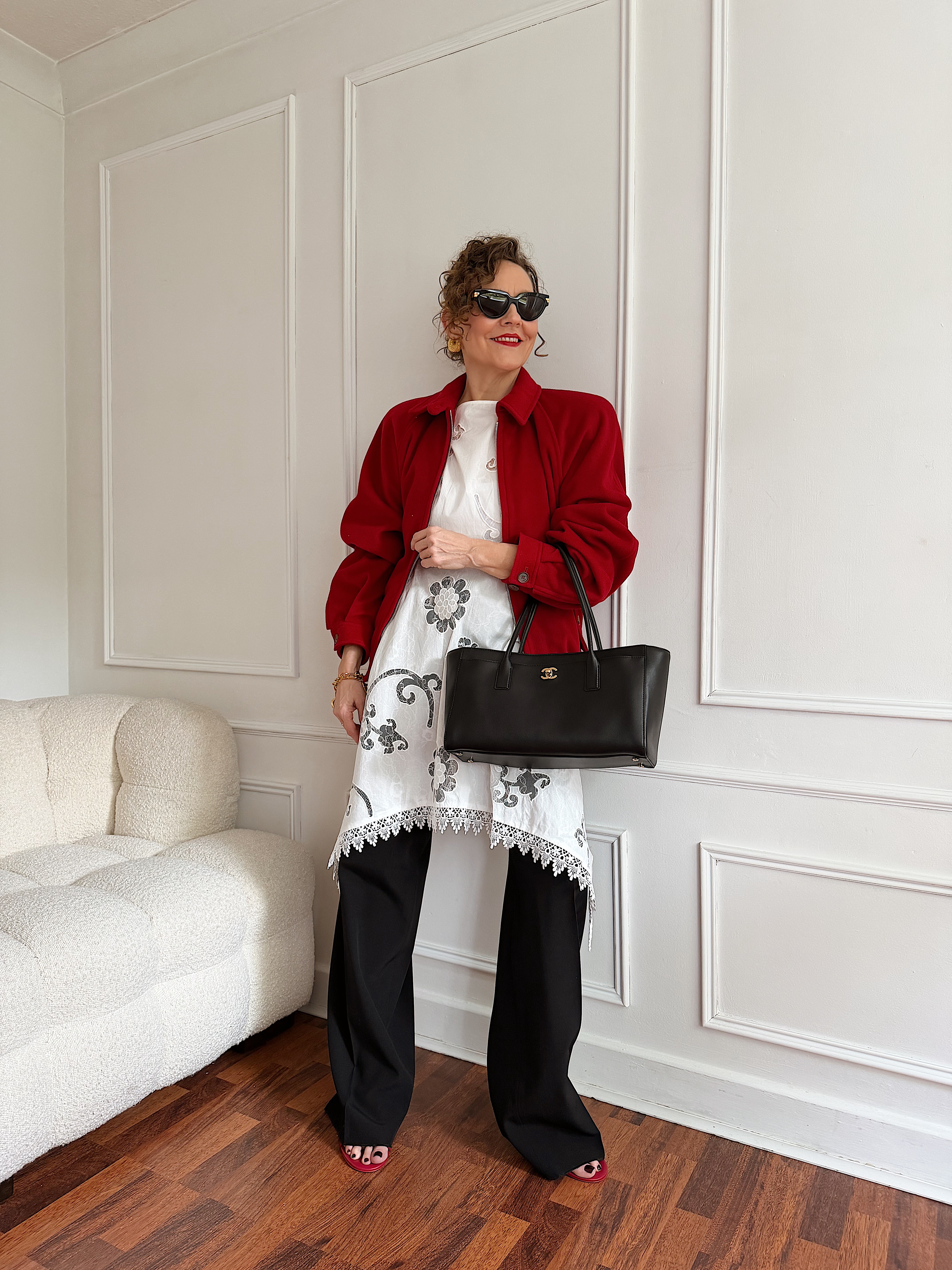 Renia Jazdzyk wears a red jacket over a dress and pants, with a black leather Chanel bag