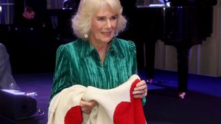 Britain's Queen Camilla receives gifts of Valentine's Day jumpers bearing red hearts for herself and Britain's King Charles III during the "Celebration Of Shakespeare" event at Grosvenor House in London on February 14, 2024. (Photo by Chris Jackson / POOL / AFP)