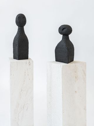 View of the black ‘Seth & Sekhmet’ vases by Studiopepe on plinths pictured against a light coloured background